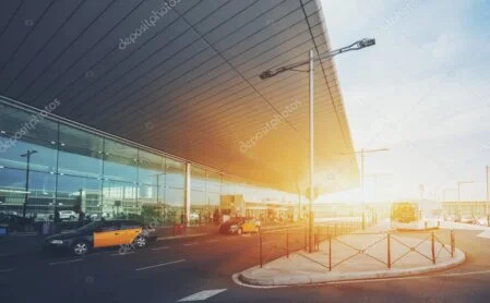 Chauffeur de taxi aidant des passagers avec leurs bagages devant un terminal